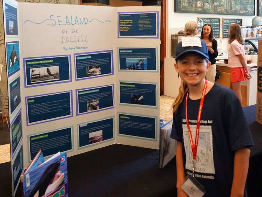 Student delegate at the 2024 Provincial Heritage Fair stands next to their project titled: Sealand of the Pacific.