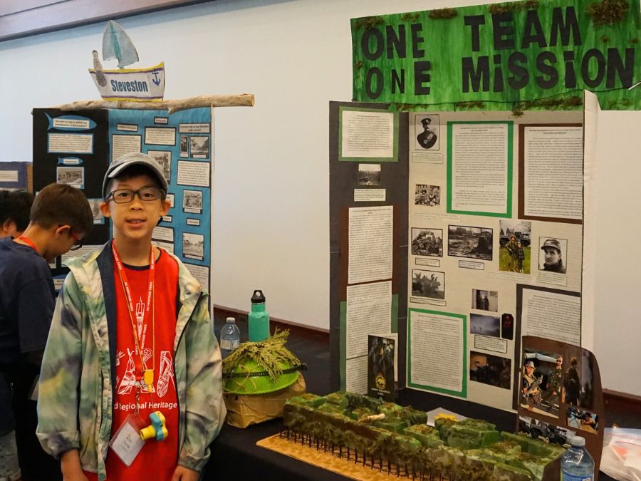 Student delegate at the 2024 Provincial Heritage Fair stands next to their project titled: One Team, One Mission