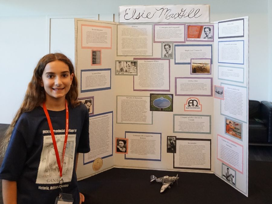 Student delegate at the 2024 Provincial Heritage Fair stands next to their project titled: Elsie MacGill.