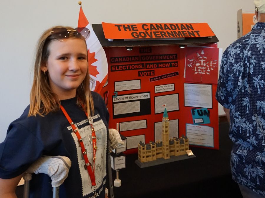 Student delegate at the 2024 Provincial Heritage Fair stands next to their project titled: The Canadian Government.