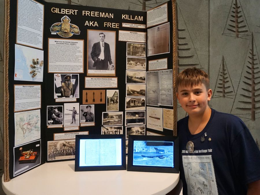 Student delegate at the 2024 Provincial Heritage Fair stands next to their project titled: Gilbert Freeman Killam AKA Free.